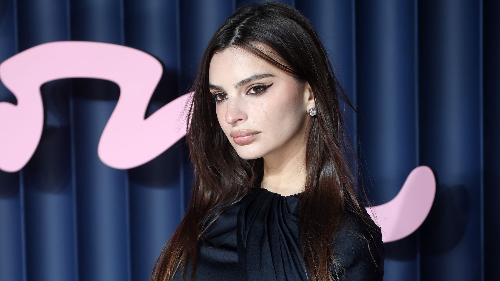 emrata in black mini dress with slinky caped wings