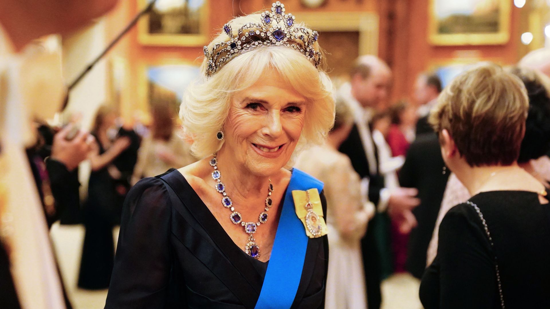 Camilla in blue dress and tiara and sash