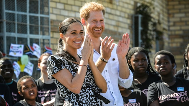 Prince Harry and Meghan laughing and clapping