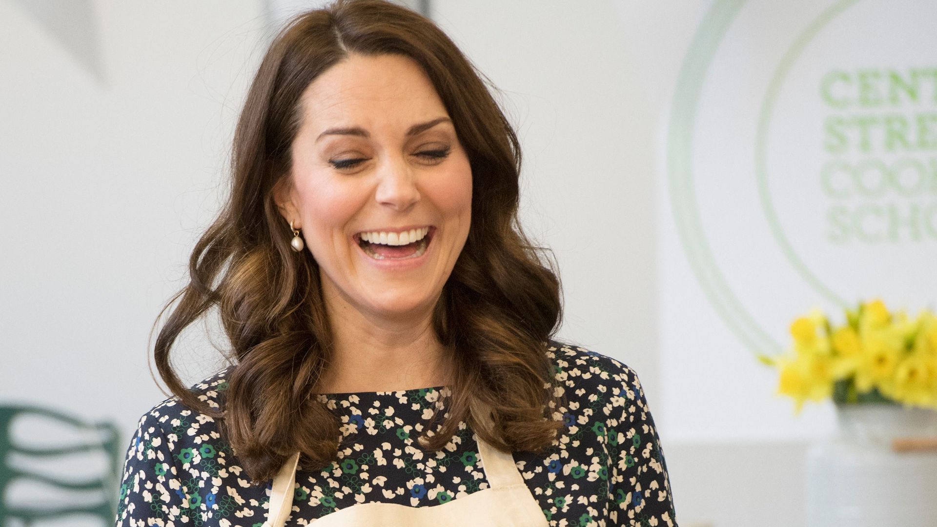 Princess Kate laughs while standing in of table of food during the Commonwealth Big Lunch
