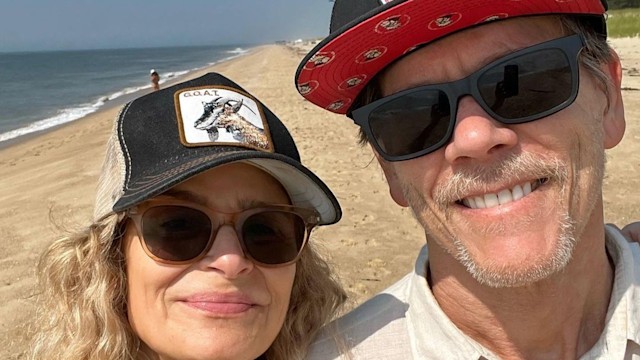 Kyra and Kevin smiling at the beach both wearing sunglasses