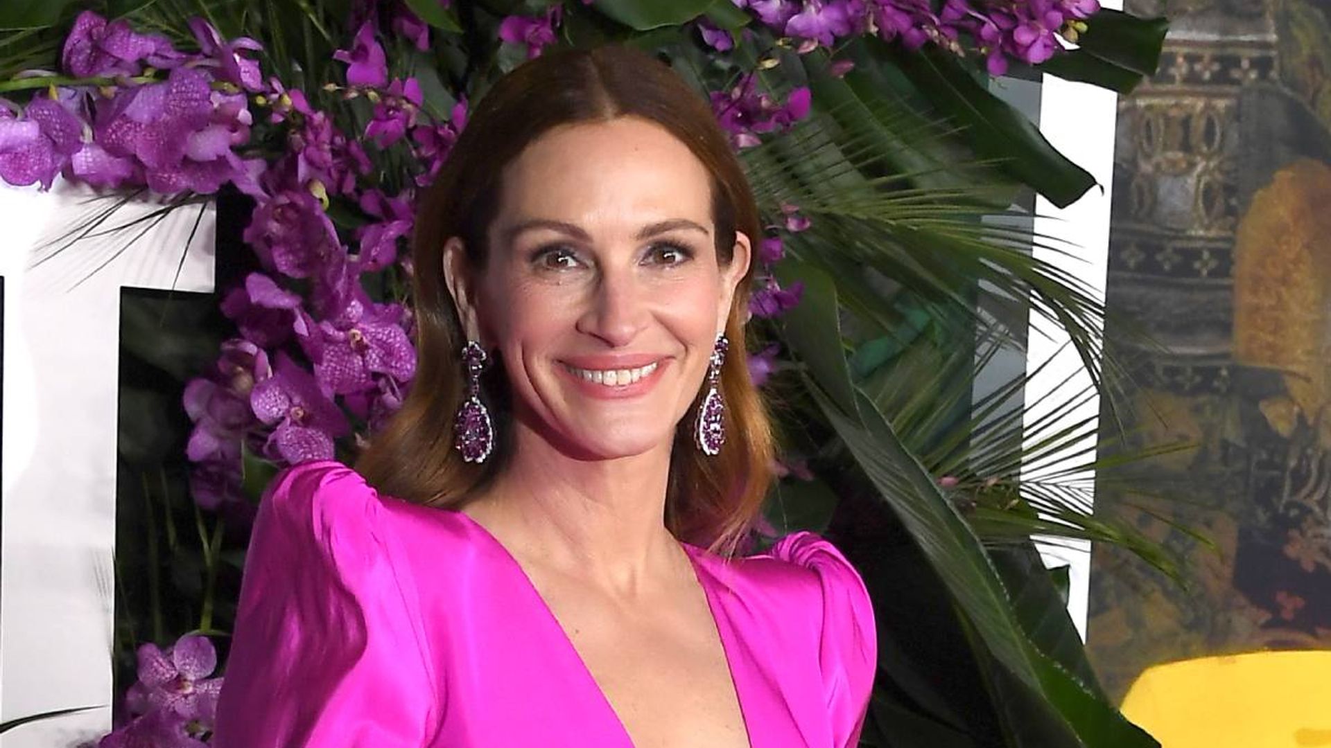 Julia Roberts is glowing in plunging bright pink gown alongside