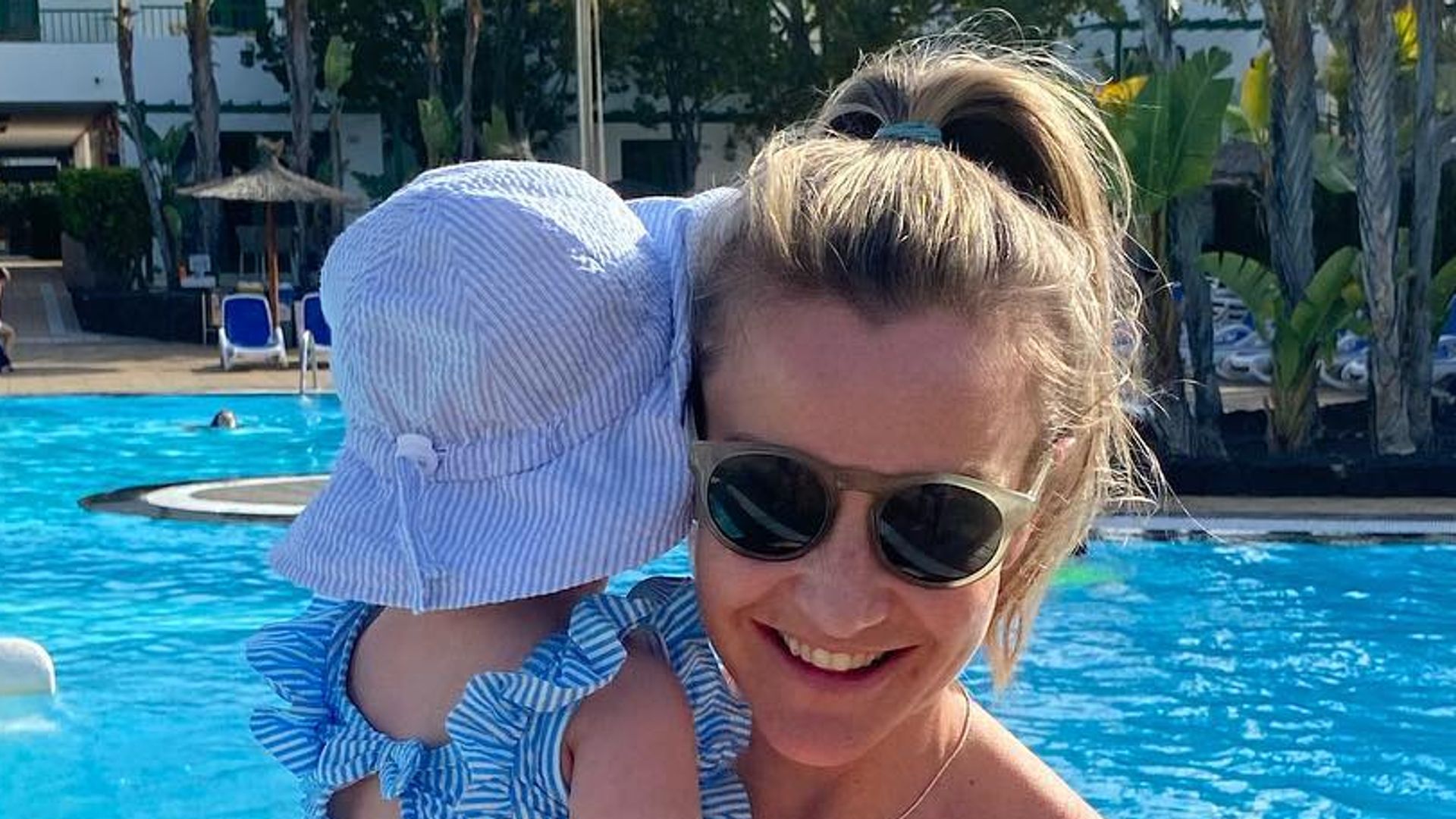 mother holding baby at pool 
