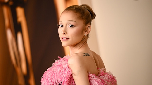 Ariana Grande looking over her shoulder in a pink feathered dress