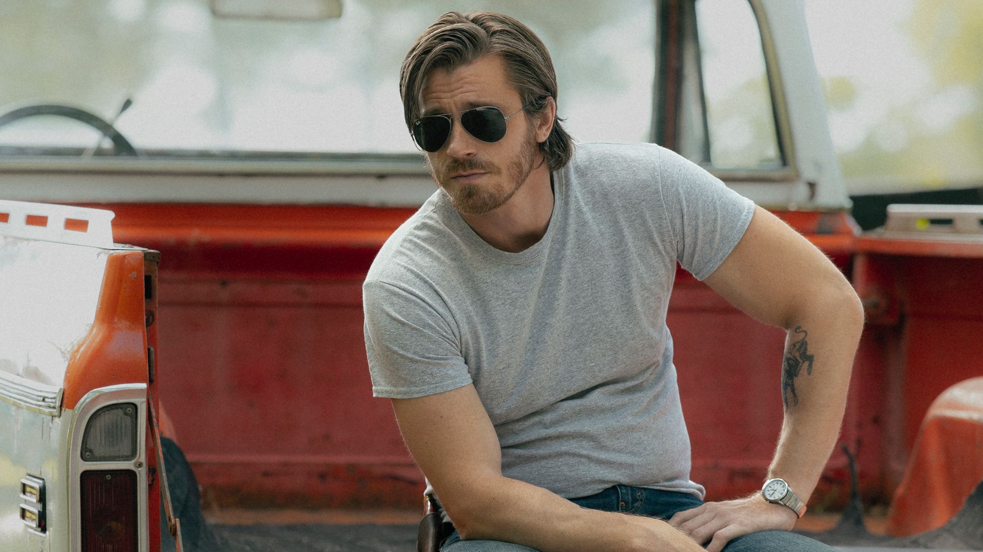 man sitting in open boot of truck