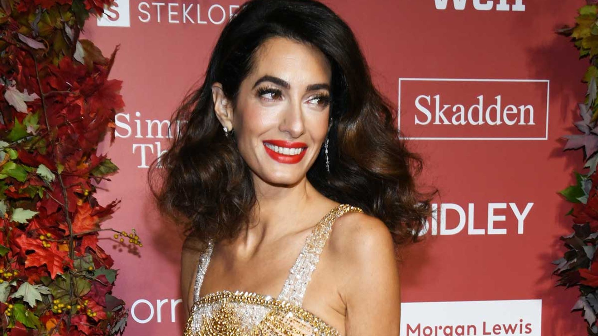 Amal Clooney dazzles in gold dress – and George can't take his