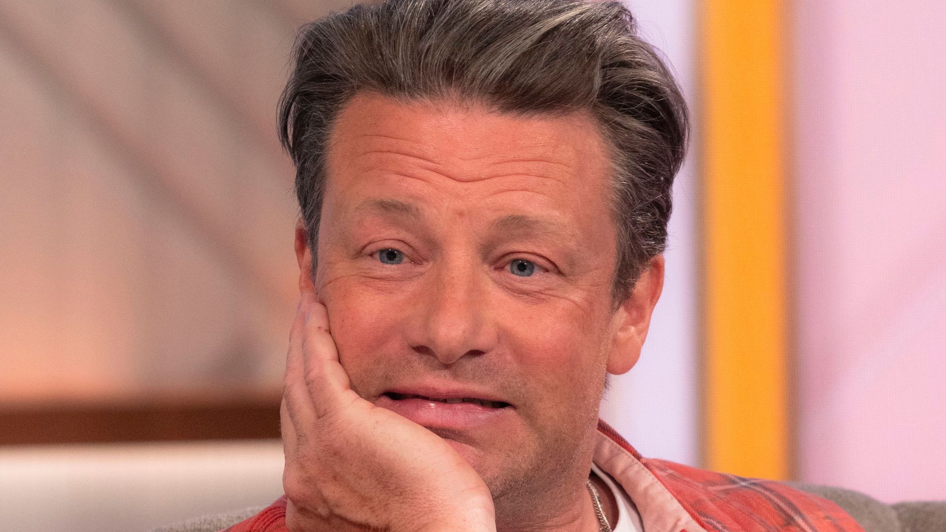 Jamie Oliver in a checked shirt with a grimace on his face