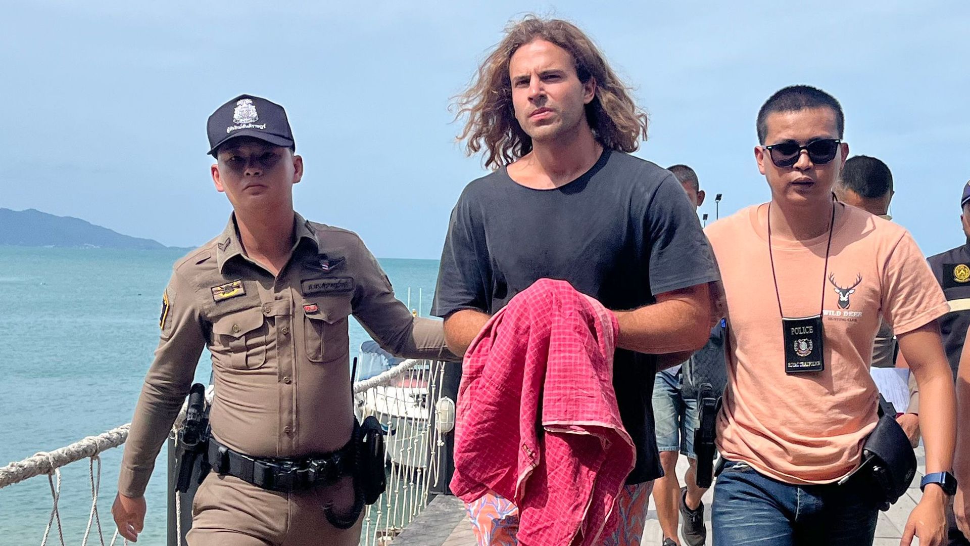 A Spanish chef alleged murder suspect Daniel Jeronimo Sancho Bronchalo is escorted by Thai police officers as they arrive at a port before going to the court in Koh Samui island