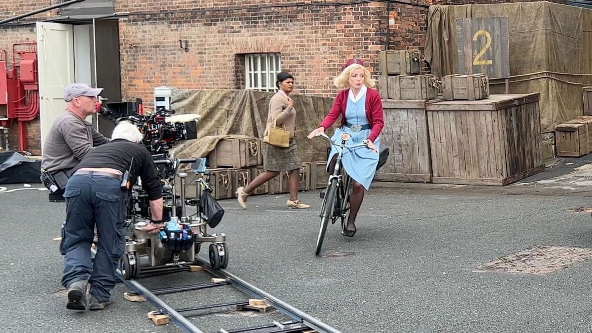Helen George riding a bike on the Call The Midwife set 