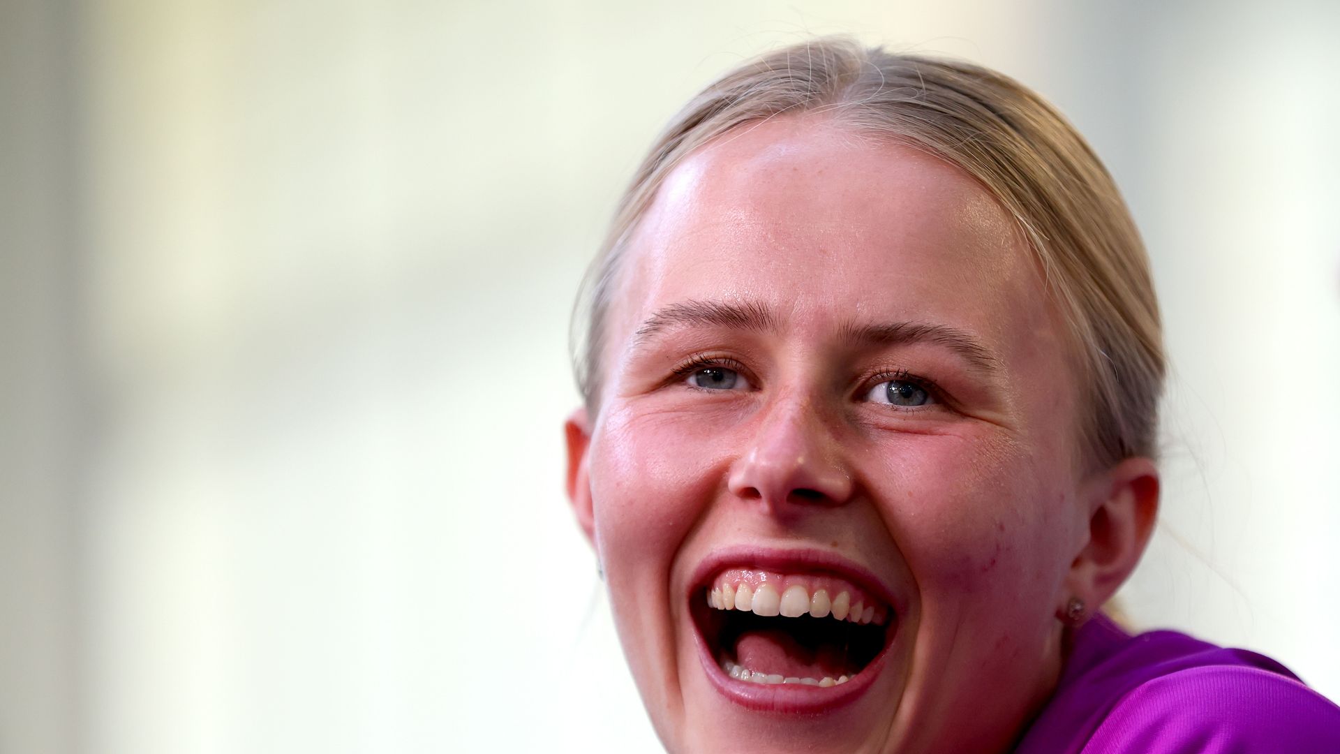 Hannah Hampton smiling widely in a purple top