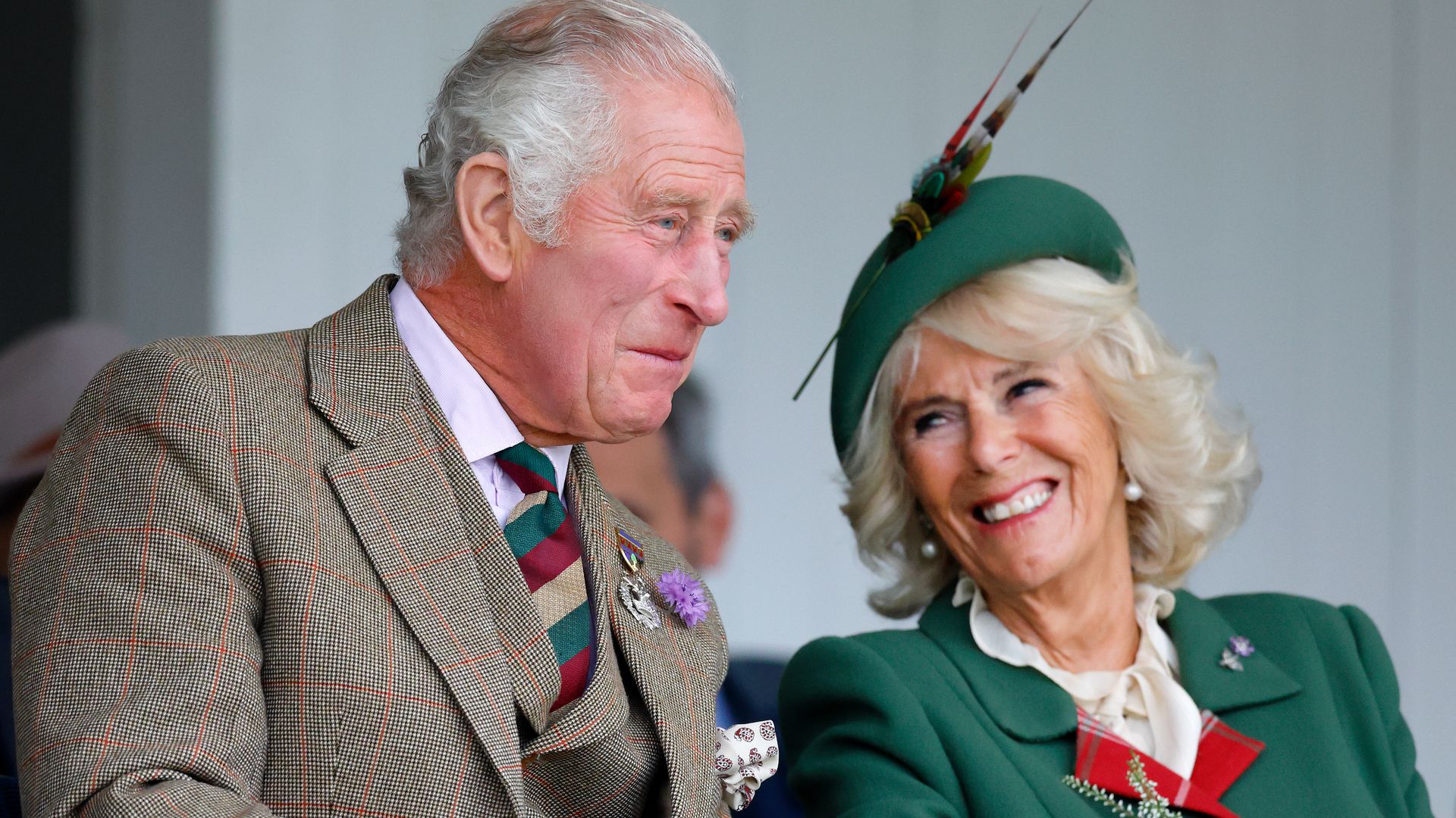 King Charles and Queen Consort Camilla laughing together at the Braemar Games in 2022