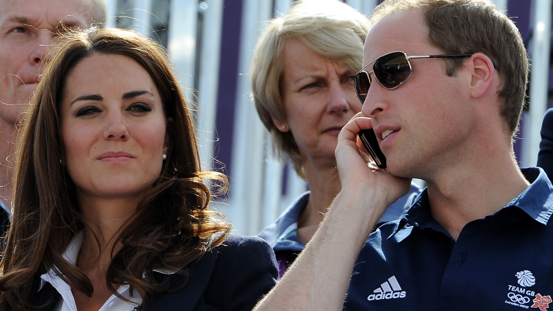 Prince William on the phone next to and Princess Kate