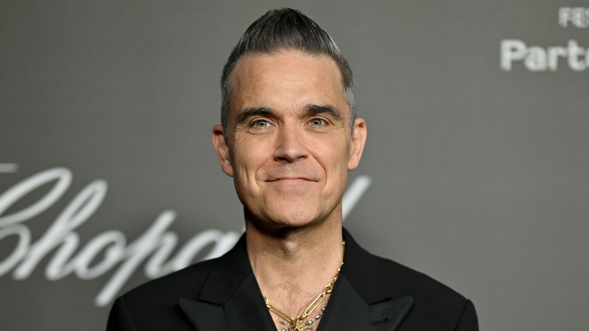 Robbie Williams smiling at a press photo opportunity