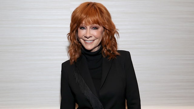 reba mcentire wearing all black and smiling for camera