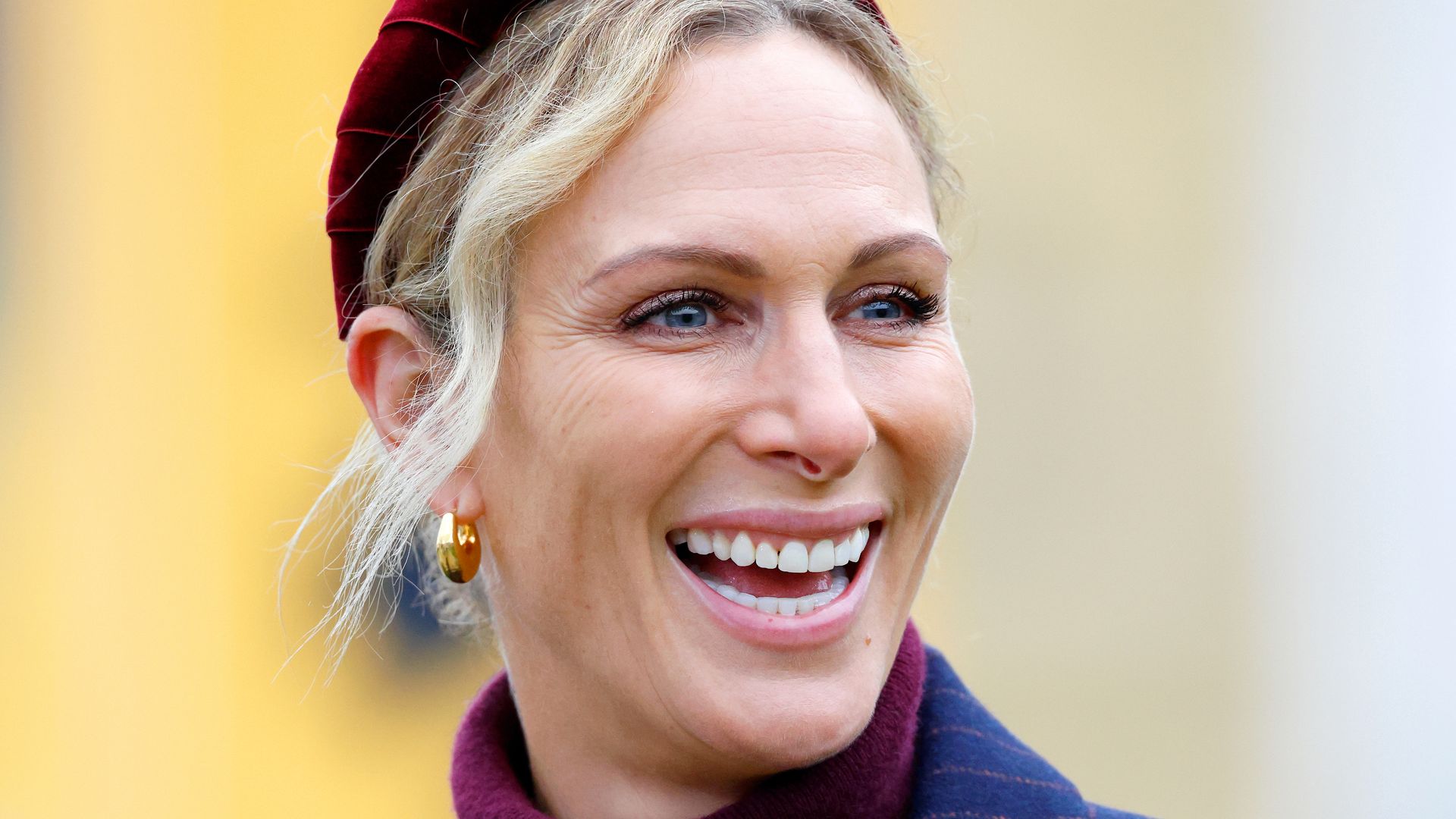 Zara Tindall in a blue jacket and red headband