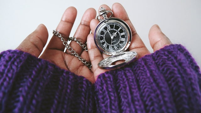 Close-up of unrecognizable black woman checking time on pocket watch