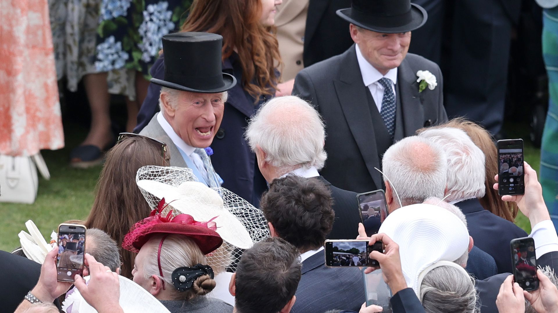 King Charles laughing with a group of guests