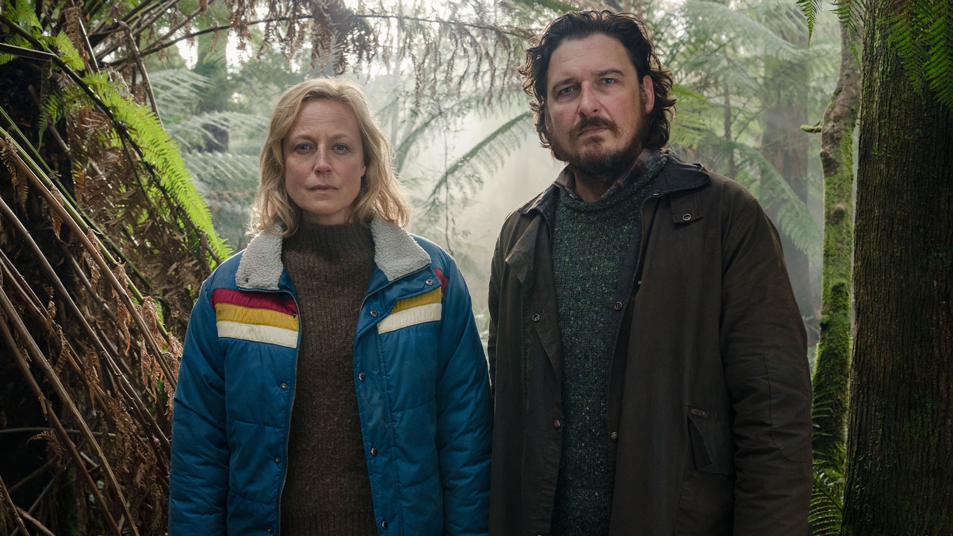 woman and man standing in woodland