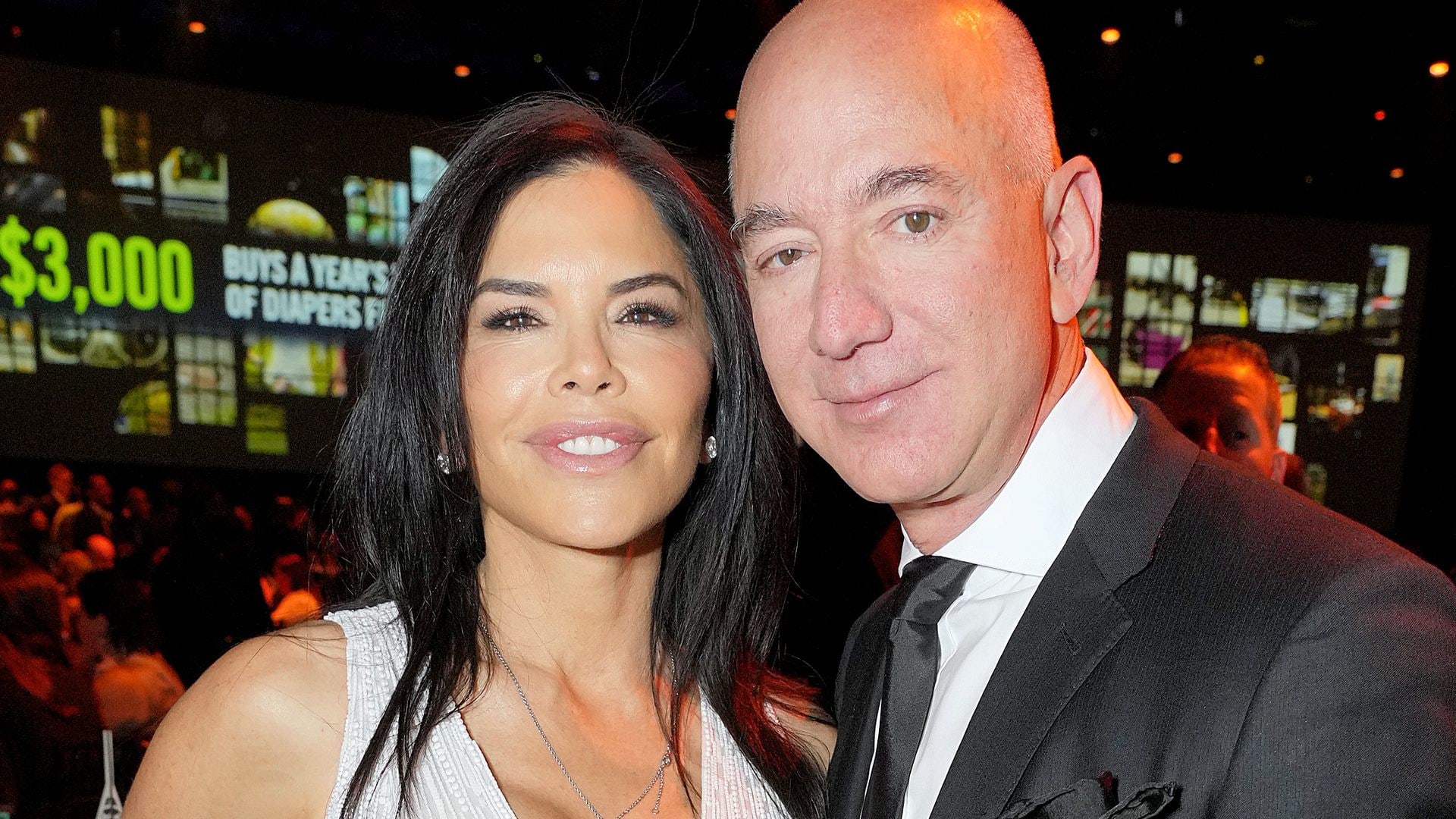 Lauren Sanchez in a white embellished dress with Jeff Bezos in a suit
