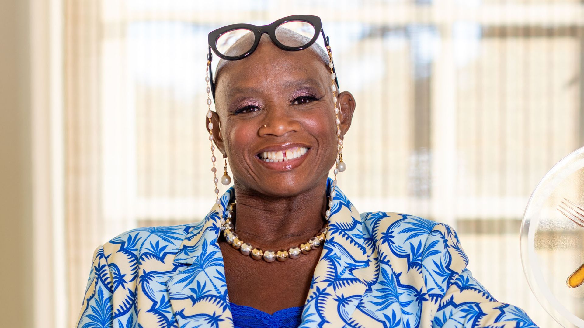 Andi OIiver smiling in a blue and cream outfit