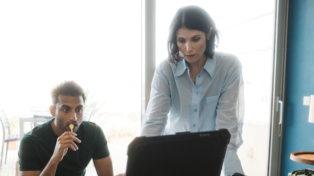 man and woman looking at computer in room