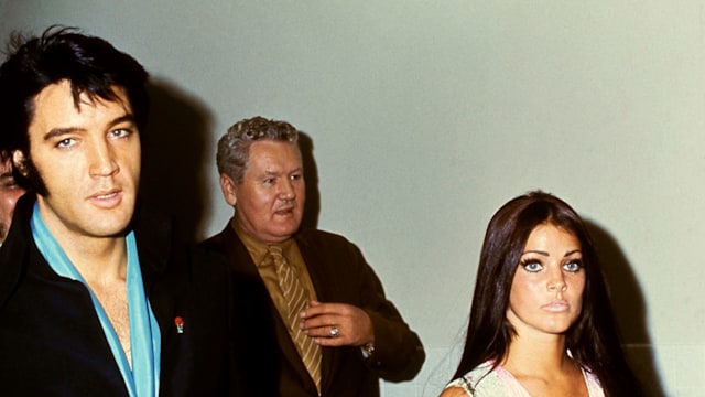 American singer Elvis Presley (1935 - 1977) walks with his wife, actress Priscilla Presley and father Vernon Presley circa 1970