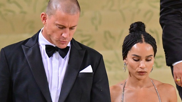 Channing Tatum in a suit walking down stairs with Zoe Kravitz