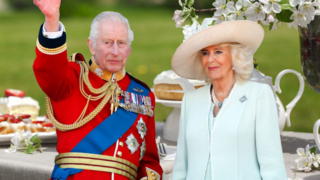 King Charles and Queen Camilla with afternoon tea backdrop