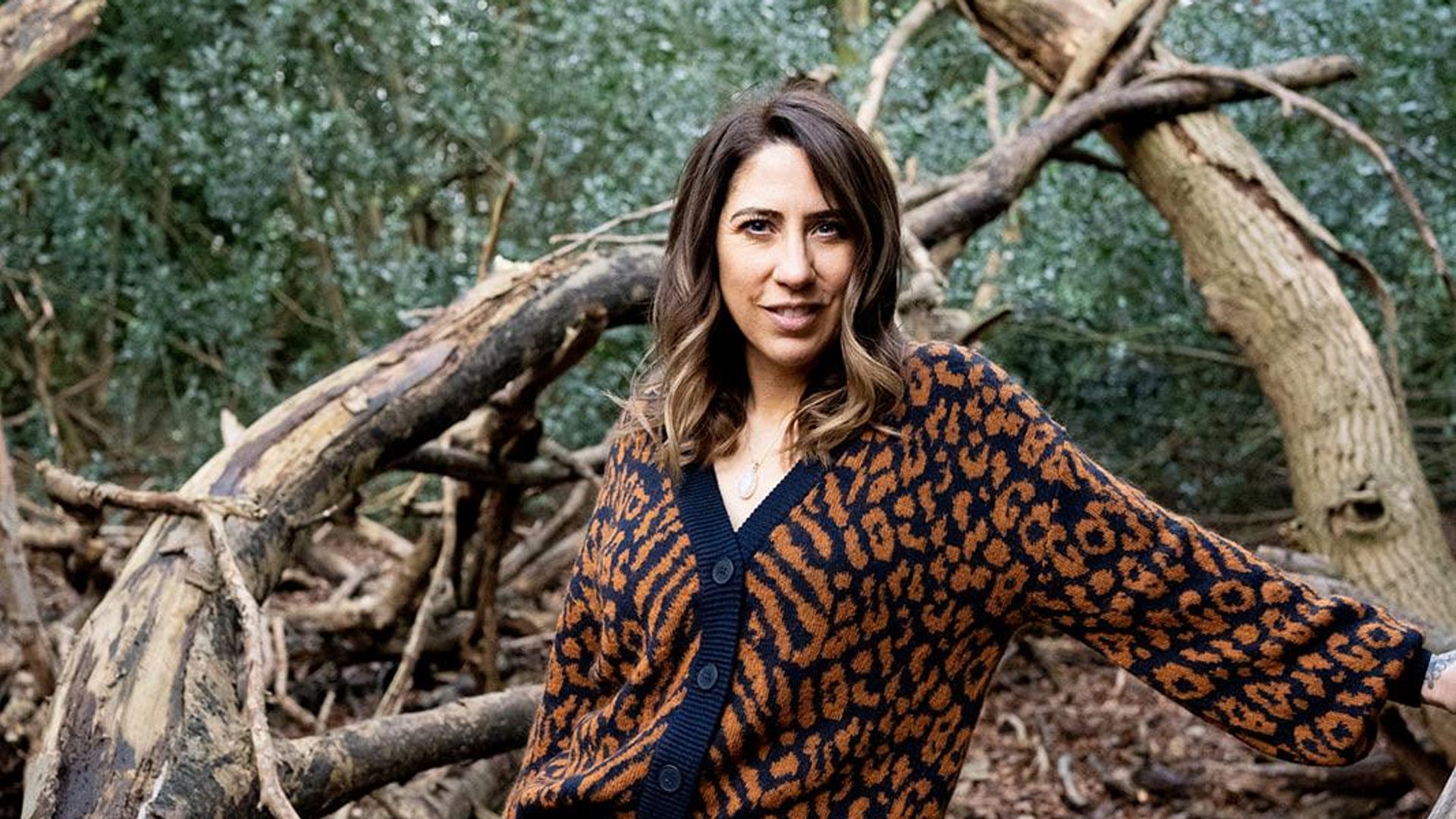 Woman in the woods in patterned cardigan
