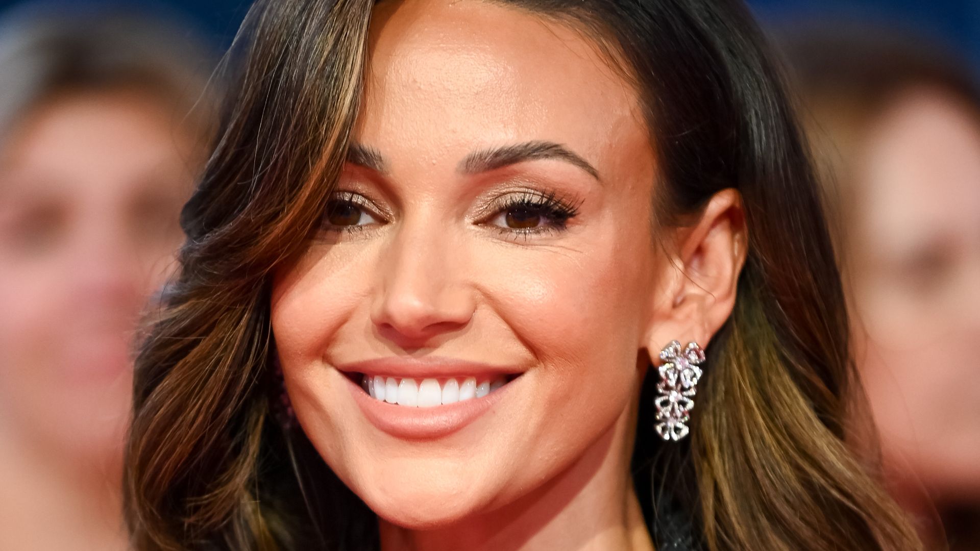 michelle keegan smiling in black sparkly dress