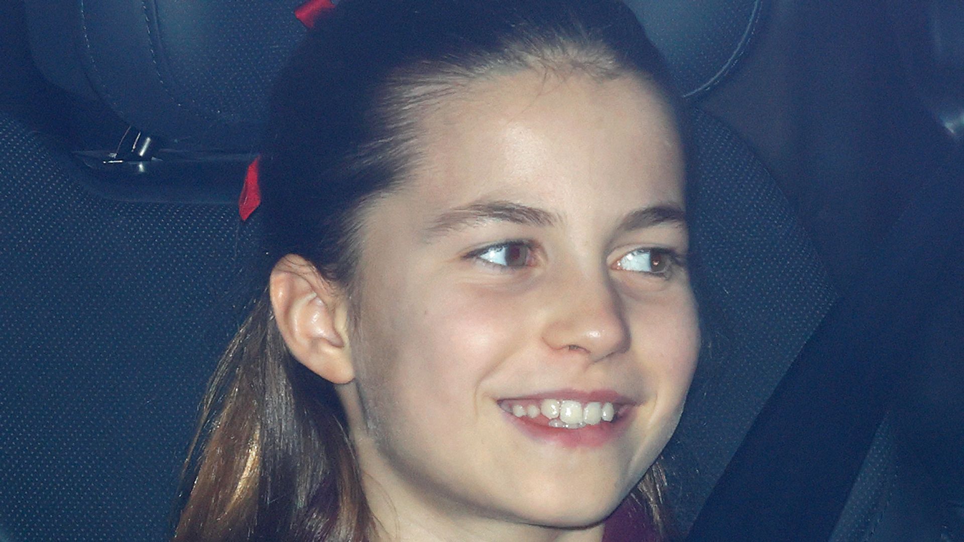 Princess Charlotte in car with red hair bow