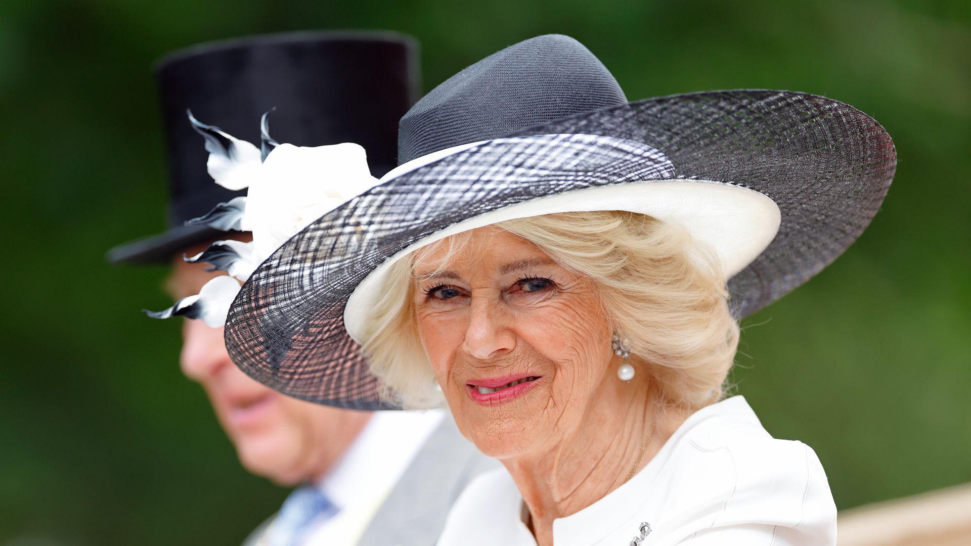Queen Camilla side on in white hat