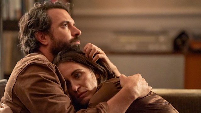 man and woman cuddling on sofa