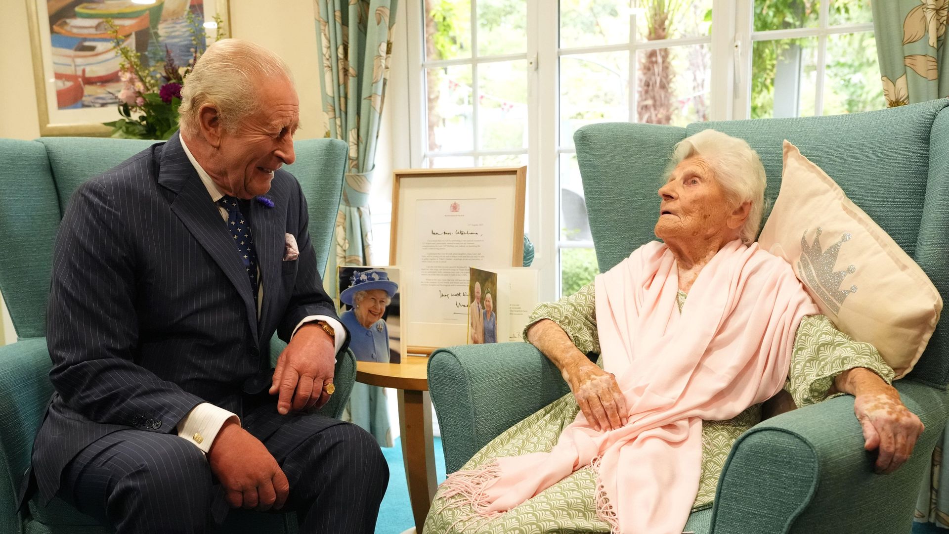 King Charles laughing at a comment from Ethel Caterham