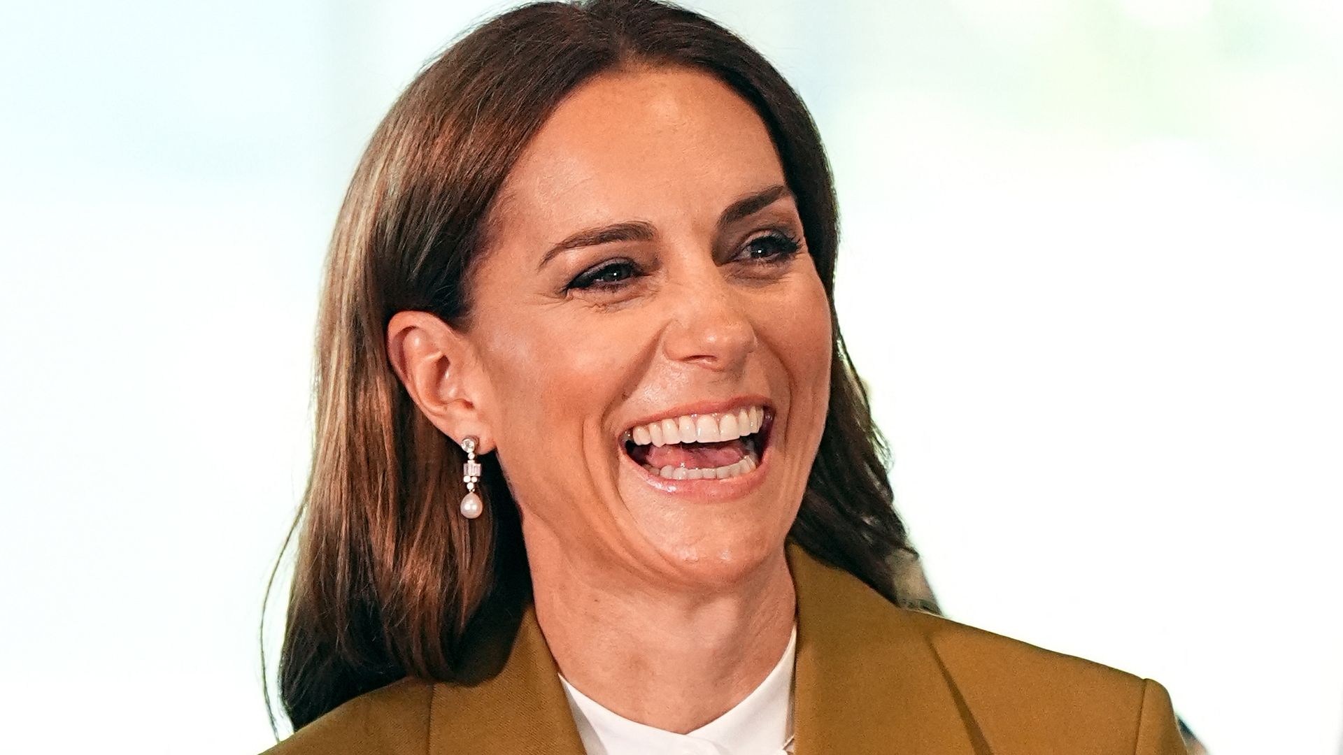 Kate Middleton smiling in olive suit