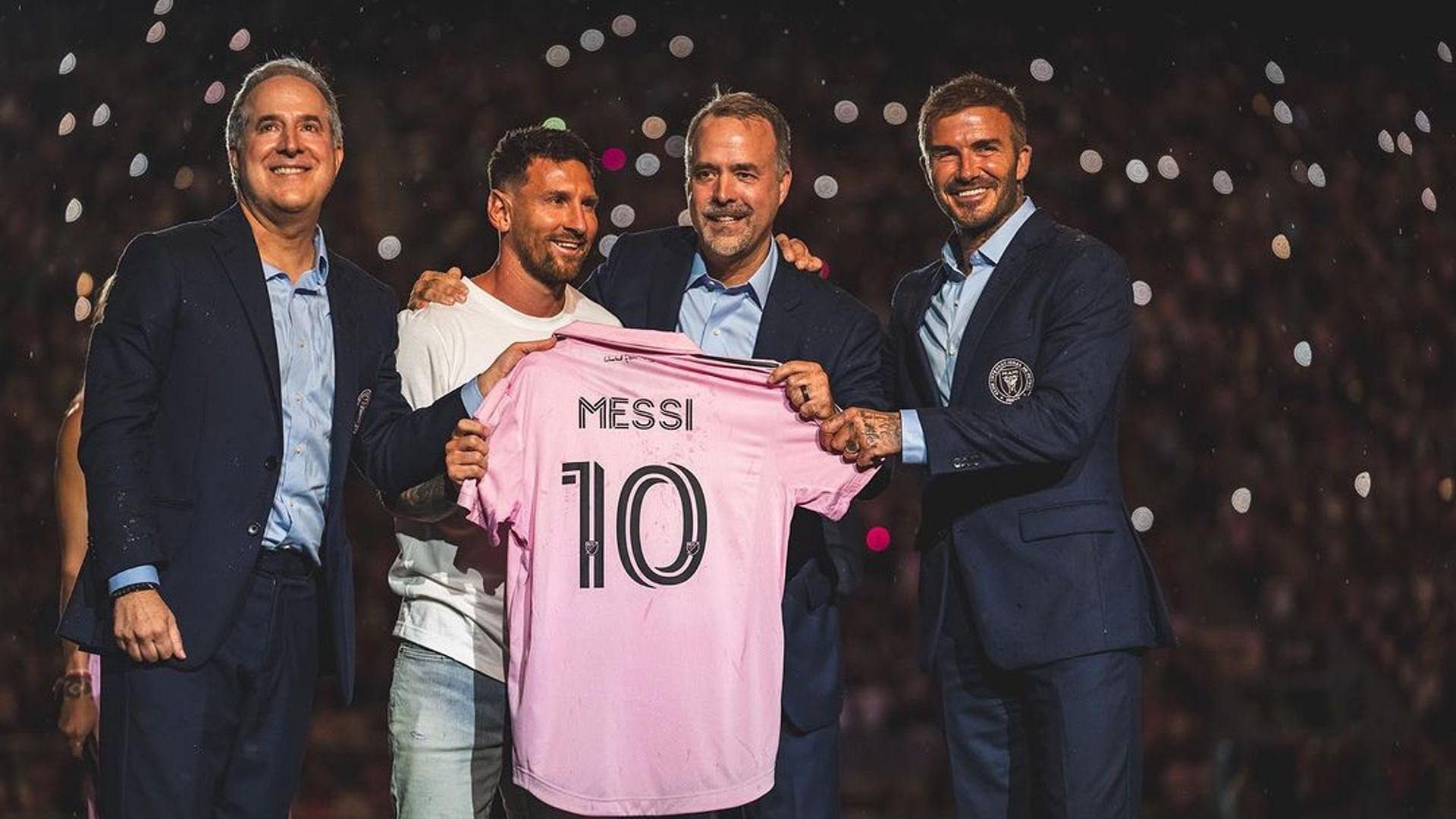 Lionel Messi holding his Inter Miami shirt alongside David Beckham