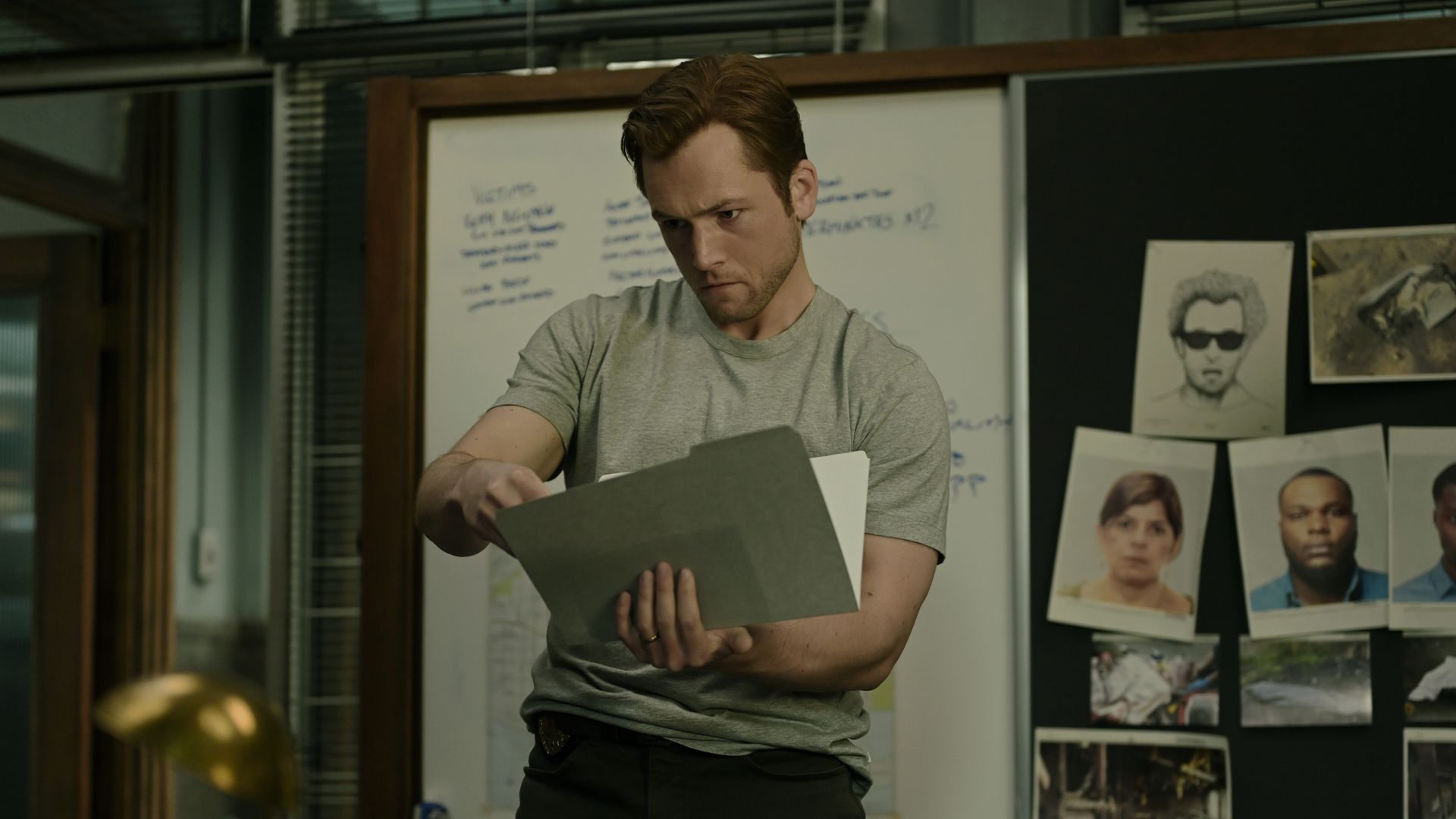 man looking at files in office