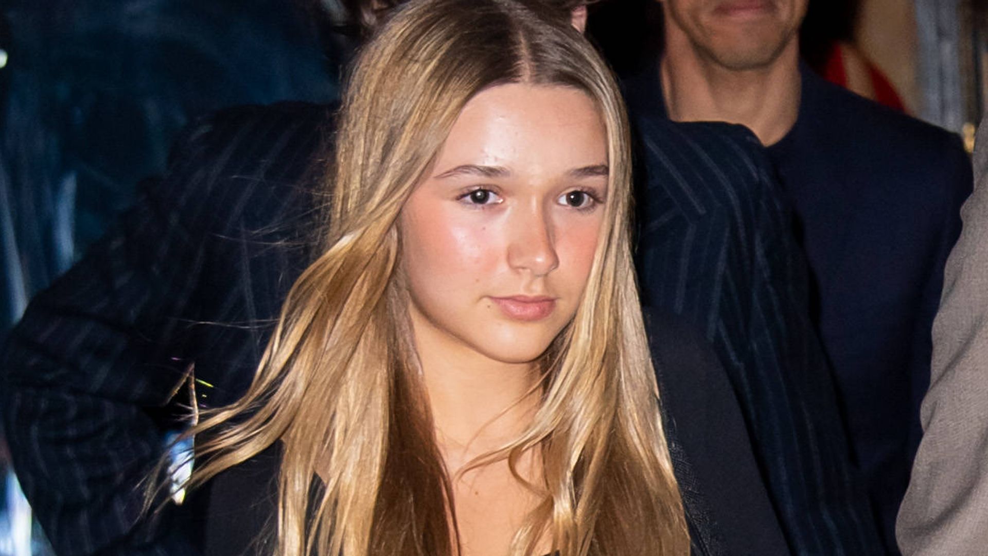 Harper Beckham in a black slip dress with her hair worn straight