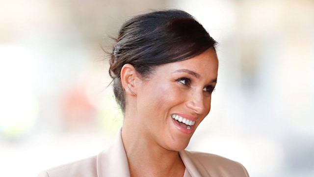 Meghan Markle smiling in a cream suit