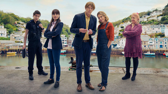 The cast of Beyond Paradise standing in the fictional 'Shipton Abbott' harbour