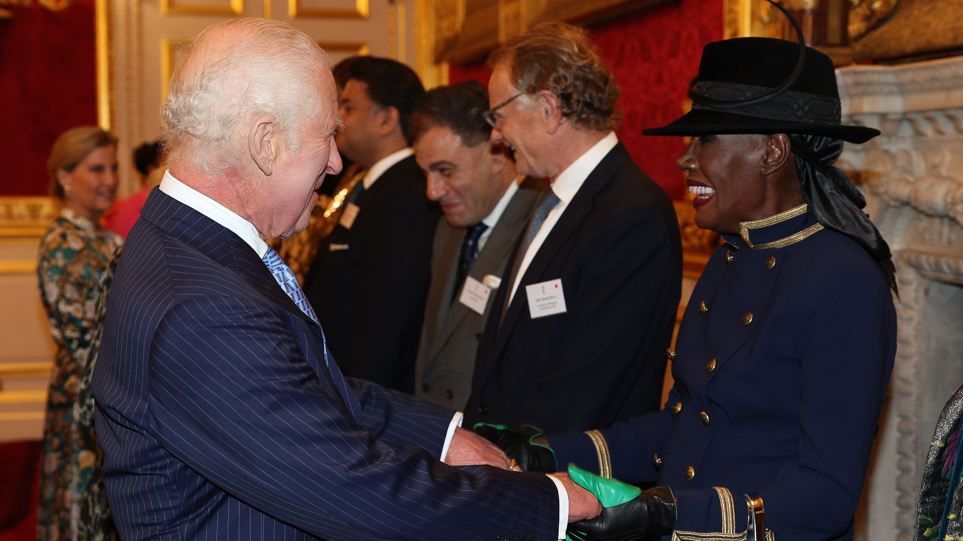 King Charles shaking hands with Grace Jones with Duchess Sophie in the background