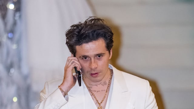 man in white suit on phone