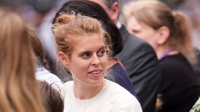 woman in white jumper standing in crowd