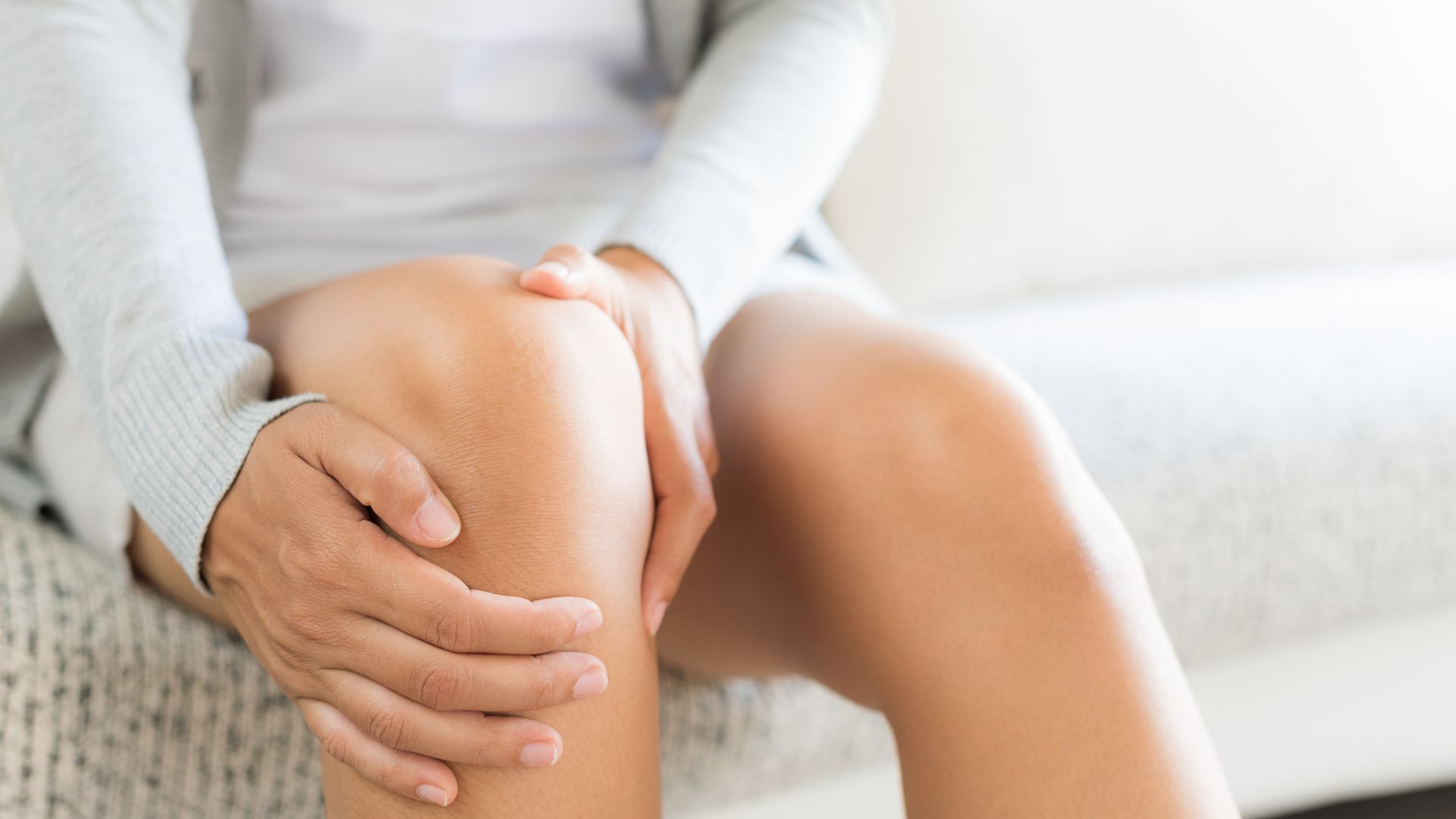 woman holding painful knee