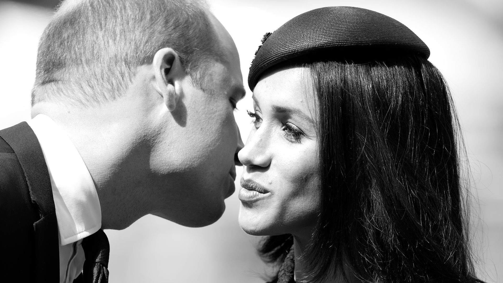 Prince William and Meghan Markle kissing in black and white photo
