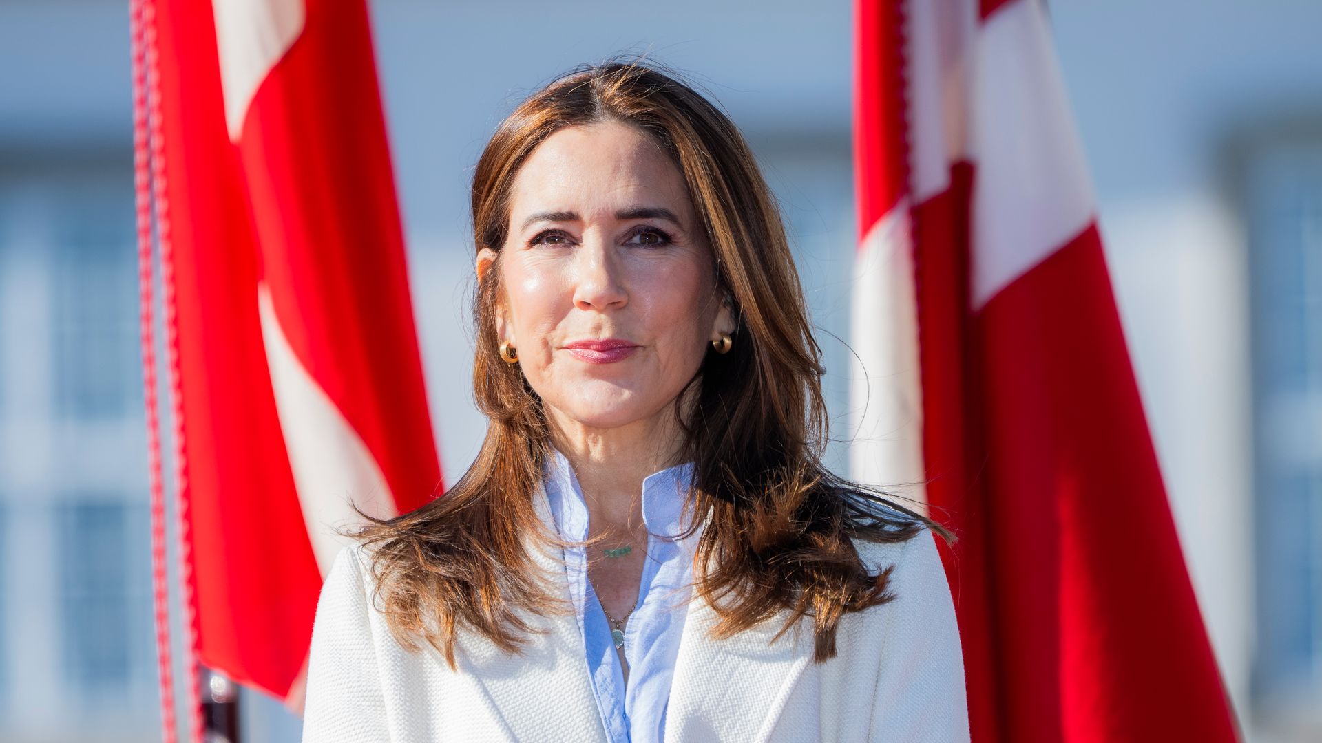 Queen Mary standing in front of Danish flags
