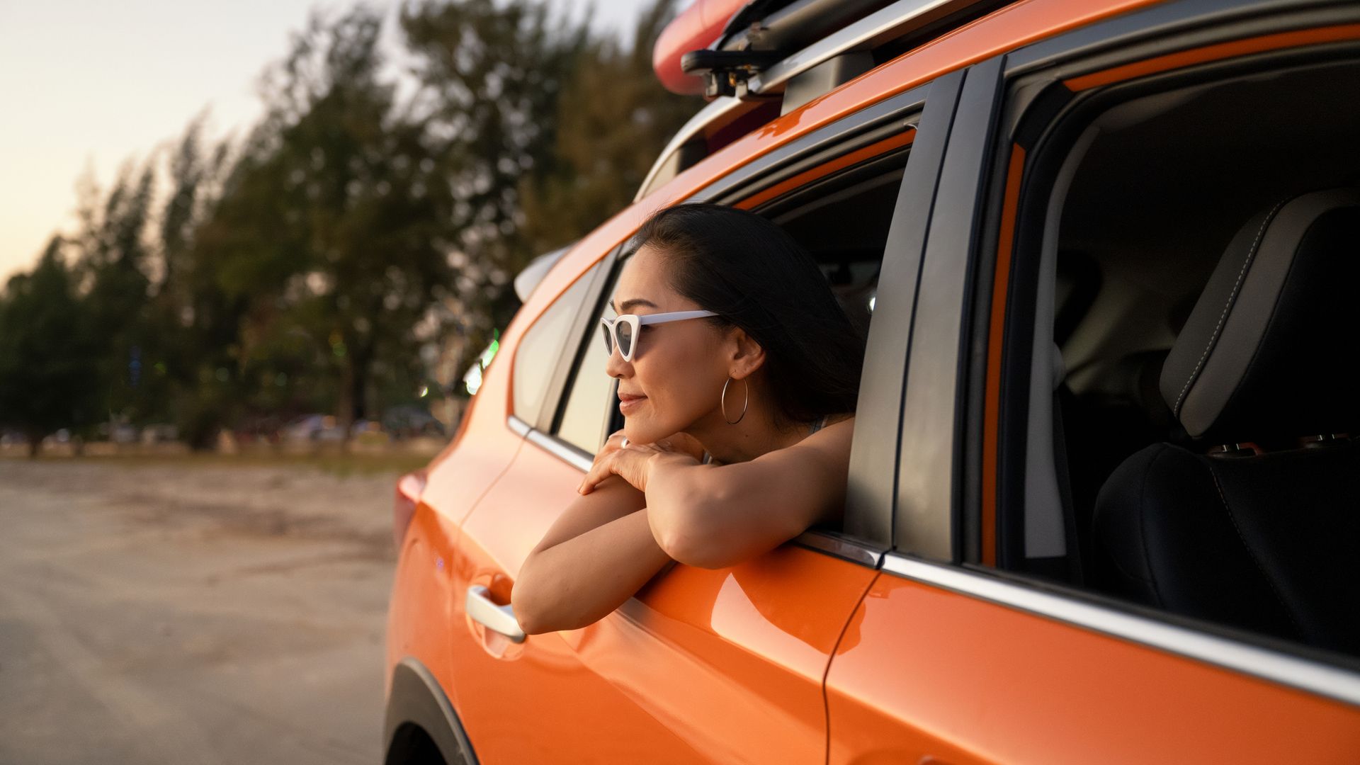 woman leaning out of car window while on a road trip