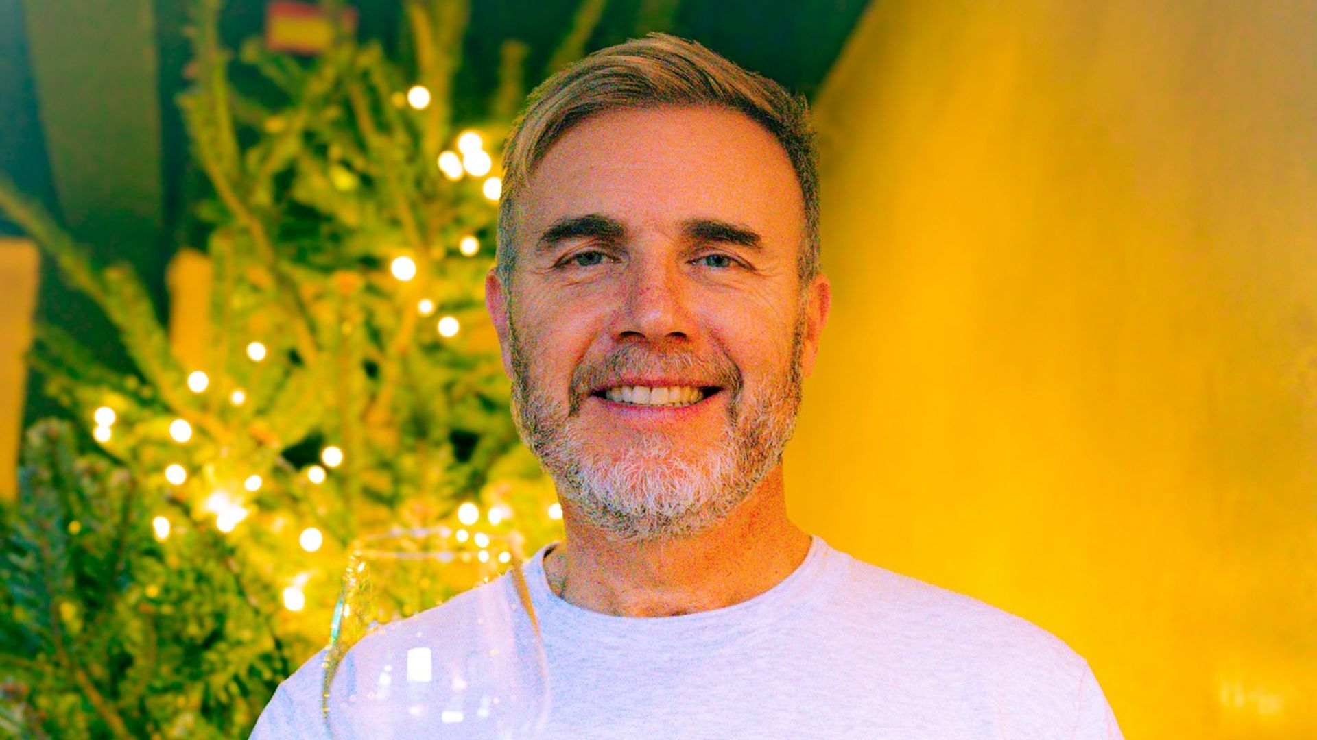 Gary Barlow with white wine in front of Christmas tree