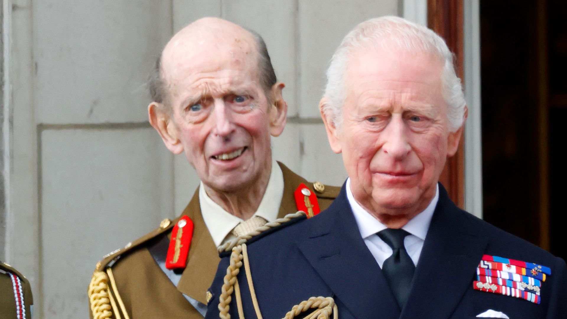 The Duke of Kent standing behind King Charles at an event