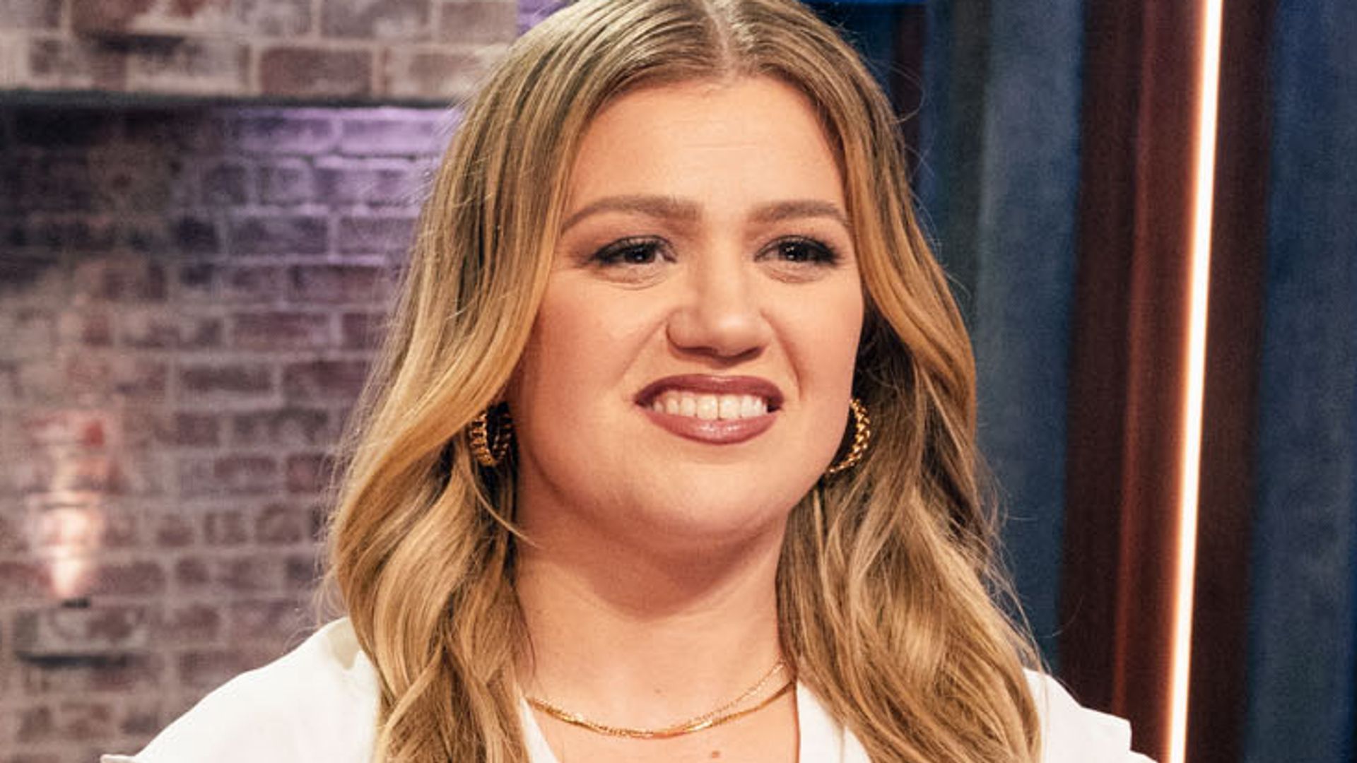 Kelly Clarkson in a white blouse and black leather trousers
